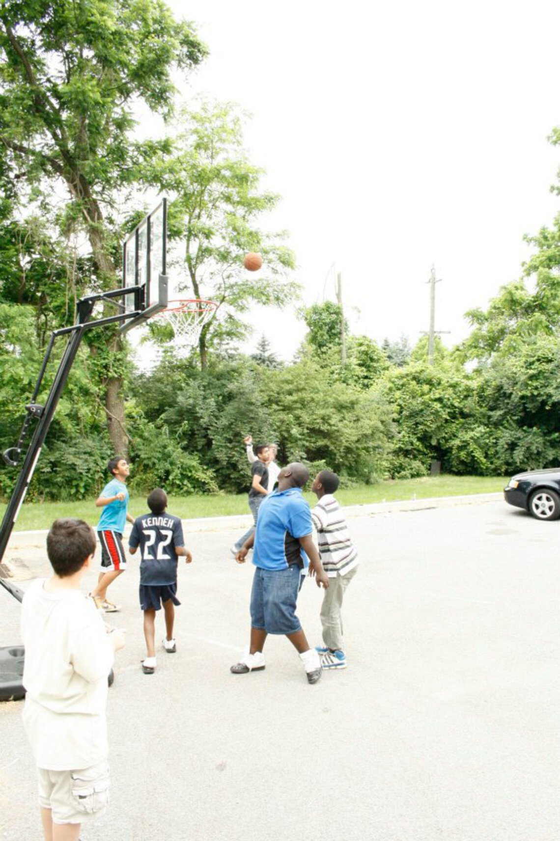 ISCC youth playing basketball in the parking lot of the ISCC